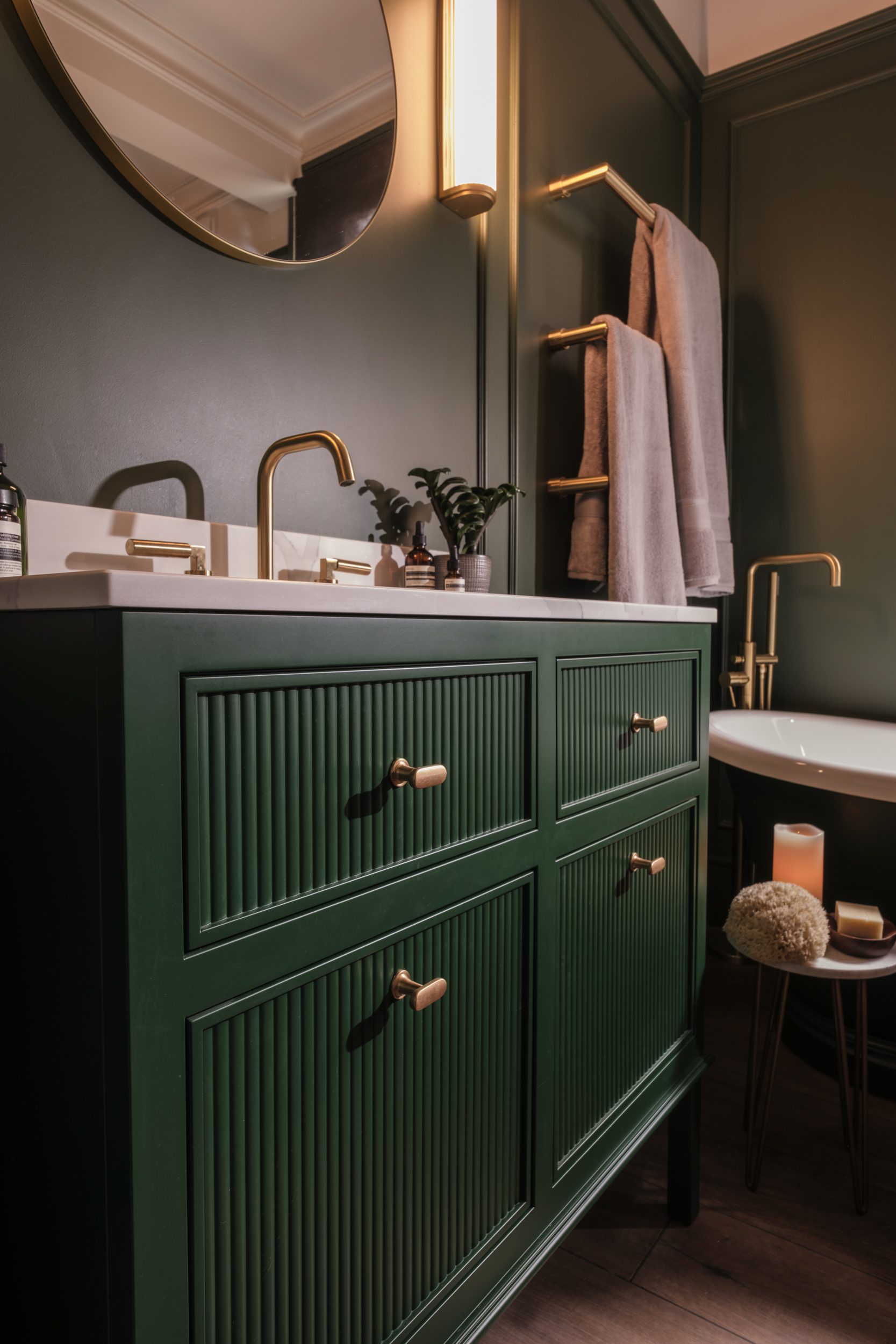 Stylish bathroom with green cabinets